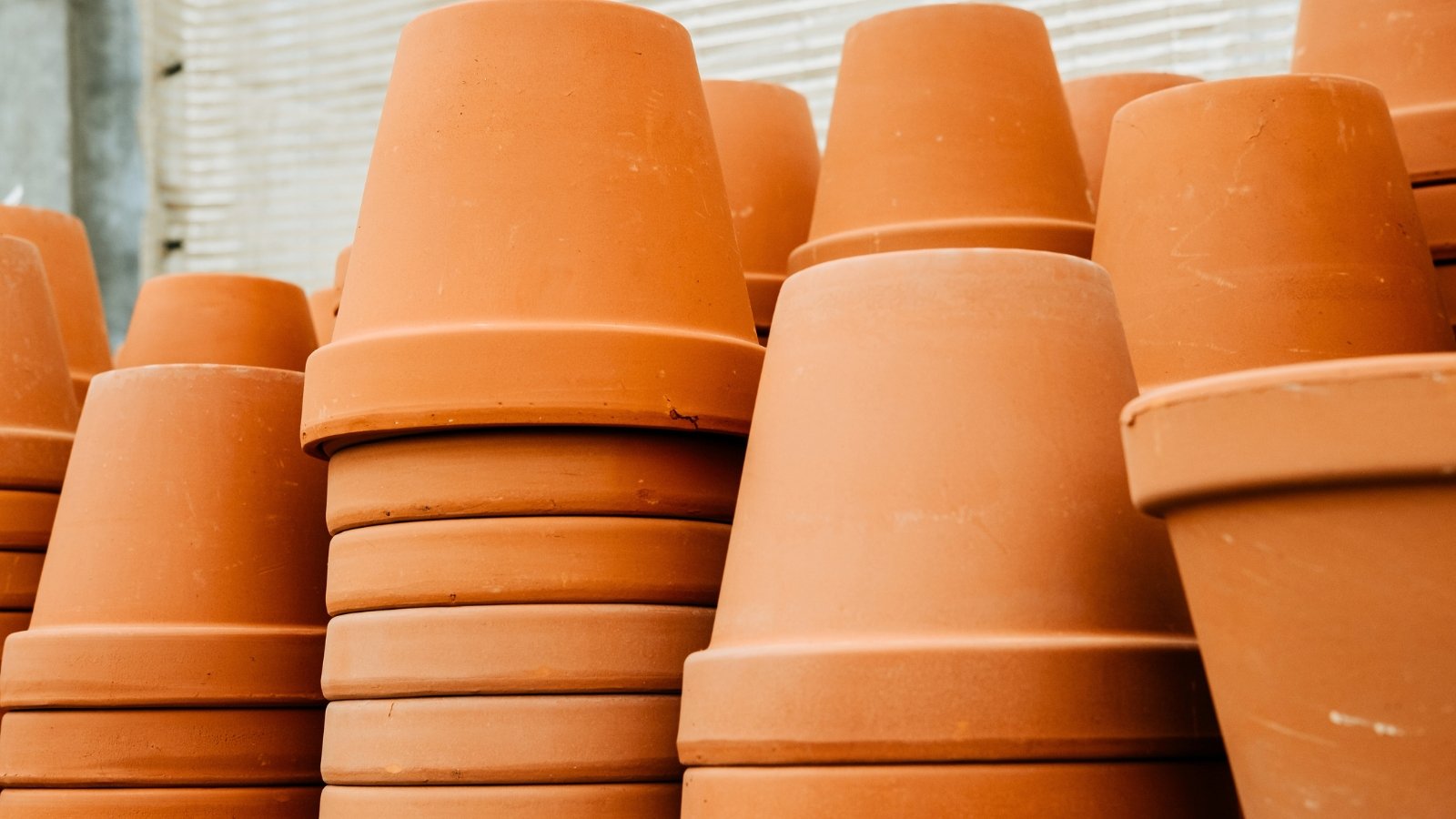 A set of stacked terracotta flower pots with a rustic, earthy texture and warm, reddish-brown color.
